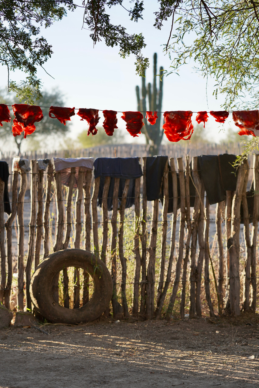 Wooden Pole Fence in Mexico with wet laundry across the top.